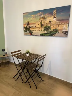 a table and chair with a painting on the wall at Dai Palermitani Rooms & Apartments in Palermo