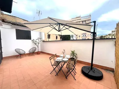 a patio with a table and chairs and an umbrella at Casa Marì Holiday House in Palermo