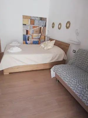 a bedroom with a bed and a chair at Casa Vacanza Giulia in Castellammare del Golfo