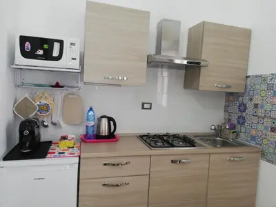 a small kitchen with a stove and a microwave at Casa Vacanza Giulia in Castellammare del Golfo