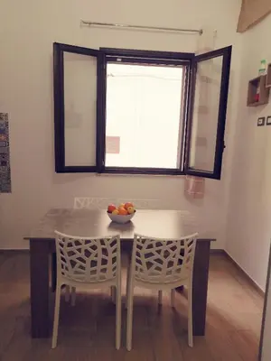 a dining room table with two chairs and a bowl of fruit on it at Casa Vacanza Giulia in Castellammare del Golfo