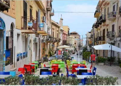 a group of tables and chairs on a city street at Casa Vacanza Giulia in Castellammare del Golfo