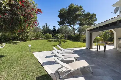 a group of white chairs sitting on a patio at Villa Perla Di Guidaloca in Scopello