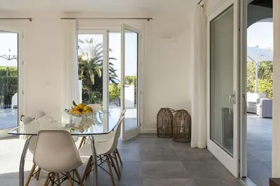 a dining room with a glass table and chairs at Villa Perla Di Guidaloca in Scopello