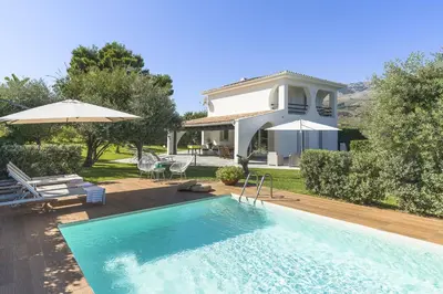 a villa with a swimming pool and a house at Villa Perla Di Guidaloca in Scopello