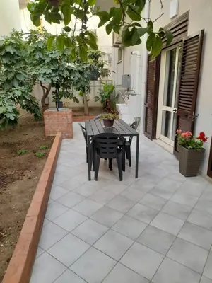 a patio with a black table and chairs on it at casa vacanza tobruk in Castellammare del Golfo