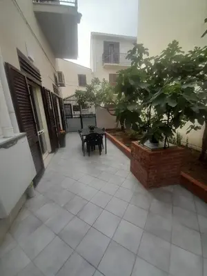 a courtyard with a table and a tree in a building at casa vacanza tobruk in Castellammare del Golfo