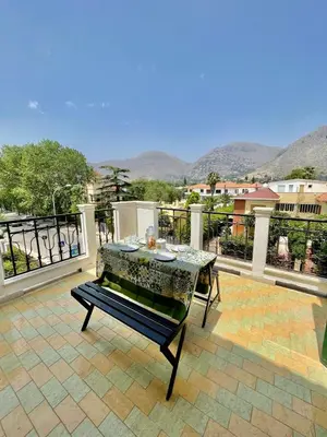 a patio with a table and a view of mountains at Catilì Apartment in Palermo