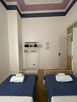 two beds in a room with blue ceilings at Catilì Apartment in Palermo
