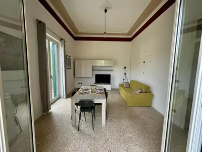 a living room with a table and a yellow couch at Catilì Apartment in Palermo