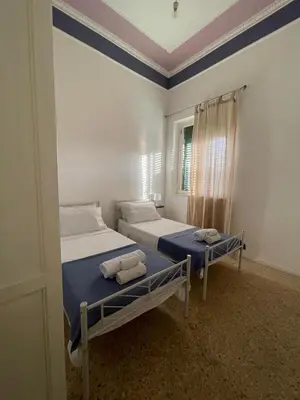 a bedroom with two beds and a window at Catilì Apartment in Palermo