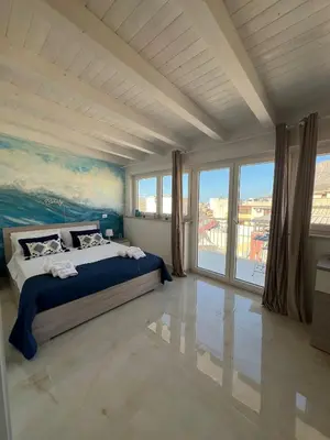 a bedroom with a bed and a large window at Terrasini Sea in Terrasini