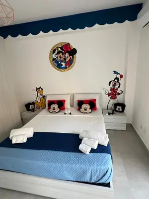a bedroom with a bed with cartoon characters on the wall at Terrasini Sea in Terrasini