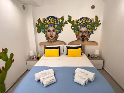 a bedroom with a bed with two heads on the wall at Terrasini Sea in Terrasini