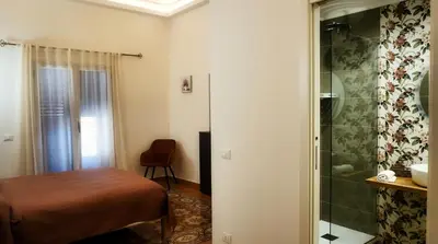 a bedroom with a bed and a glass shower at Al Duomo Suites in Monreale