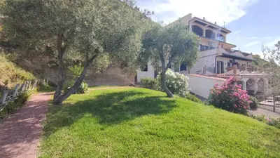a yard with two trees and a house at Costa Azzurra Cefalù Residence in Cefalù
