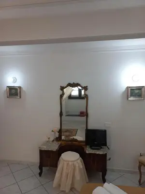 a living room with a mirror and a table at Al Palazzo Del Principe al Massimo in Palermo