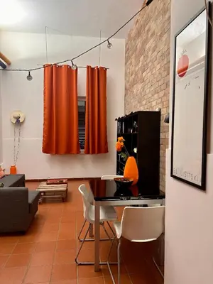 a living room with orange curtains and a table at BLU Fronte Mare in Palermo