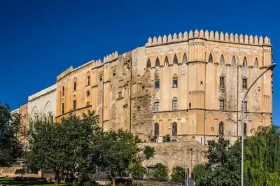 a large stone building with trees in front of it at Orleans Apartment in Palermo