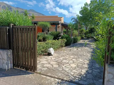 a wooden fence in front of a house at Castellaccio Scopello Villetta con piscina in Scopello