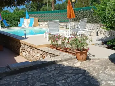 a patio with chairs and a swimming pool at Castellaccio Scopello Villetta con piscina in Scopello