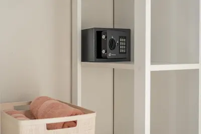 a safe in a white cabinet with a towel basket at Le perle del capo in Palermo
