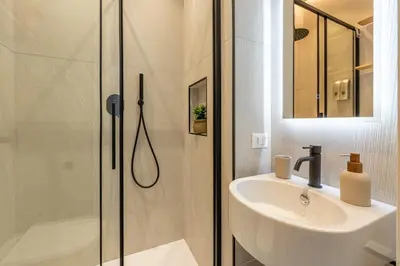 a bathroom with a glass shower and a sink at Le perle del capo in Palermo