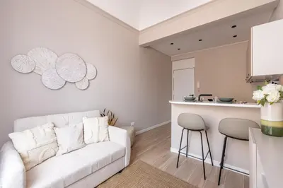 a living room with a white couch and a kitchen at Le perle del capo in Palermo
