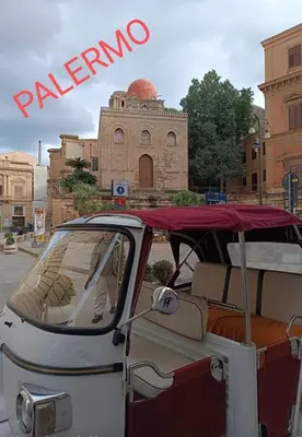 a white car with a red roof in front of a building at La dimora di Elma in Palermo