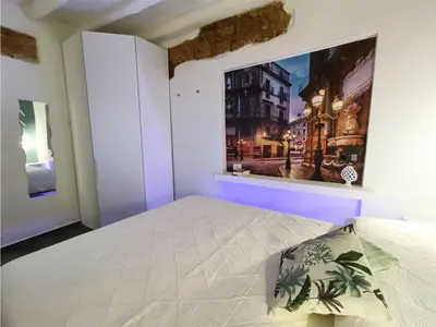 a bedroom with a bed with a painting on the wall at Agghiorna&skura 2,0 in Palermo