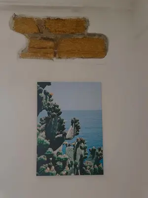 a painting of the ocean and cacti on a wall at Agghiorna&skura 2,0 in Palermo