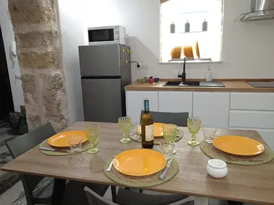 a table with orange plates and a bottle of wine at Casa varco Santa Lucia in Palermo