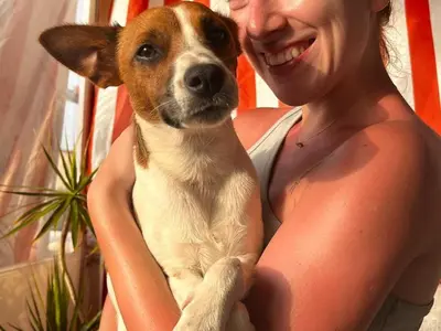 a woman holding a brown and white dog in her arms at Terrazza Mare Mondello in Palermo