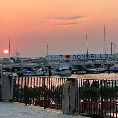 a marina with boats in a marina with the sunset at Terrazza Mare Mondello in Palermo