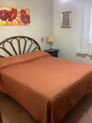 a bedroom with a bed with an orange bedspread at Macari House in Macari