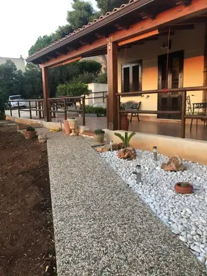 a patio with a stone walkway in front of a house at Macari House in Macari