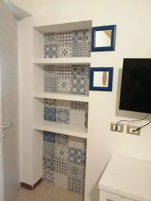 a room with blue and white tiles on the wall at Domus Case Vacanze civico del mare in Castellammare del Golfo