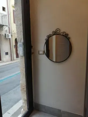 a mirror on a wall next to a door at Domus Case Vacanze civico del mare in Castellammare del Golfo