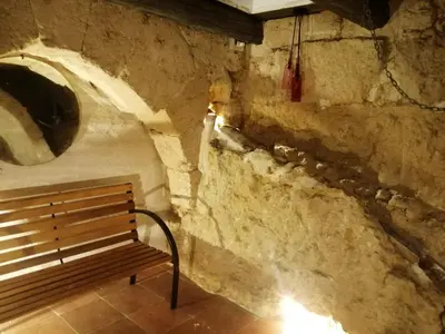 a bench sitting in a room with a stone wall at Domus Case Vacanze civico del mare in Castellammare del Golfo