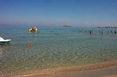 a group of people in the water at the beach at VILLA BUTTERFLY 2 a FEW STEPS FROM THE SEA in Capaci