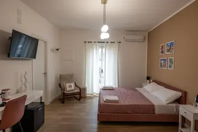 a bedroom with a bed and a tv and a chair at Molinari Palermo in Palermo