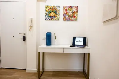 a white table with a laptop on it next to a door at Molinari Palermo in Palermo