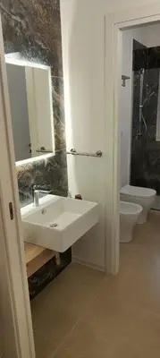 a bathroom with a sink and a toilet and a mirror at Crihouse in Palermo