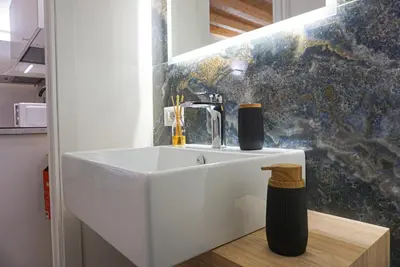 a white sink in a kitchen with a wall at Crihouse in Palermo