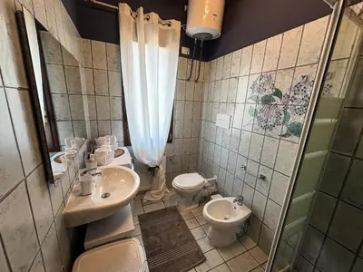 a bathroom with two toilets and a sink and a shower at Appartamento completo con parcheggio privato - Villa Ciaculli in Villabate