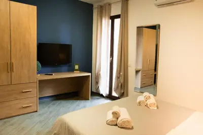 a bedroom with two towels on a bed with a television at Appartamento completo con parcheggio privato - Villa Ciaculli in Villabate