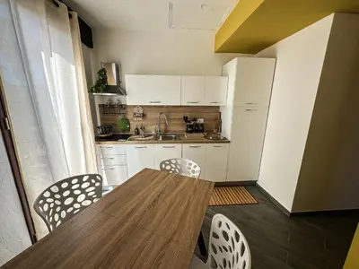 a small kitchen with a wooden table and chairs at Intero Appartamento con Terrazza - Villa Ciaculli in Palermo