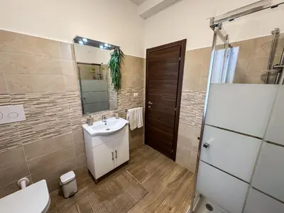 a bathroom with a sink and a toilet and a mirror at Intero Appartamento con Terrazza - Villa Ciaculli in Palermo