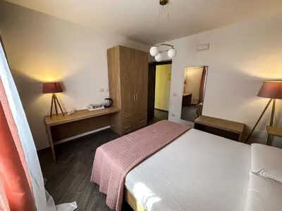 a bedroom with a bed and a desk with two lamps at Intero Appartamento con Terrazza - Villa Ciaculli in Palermo