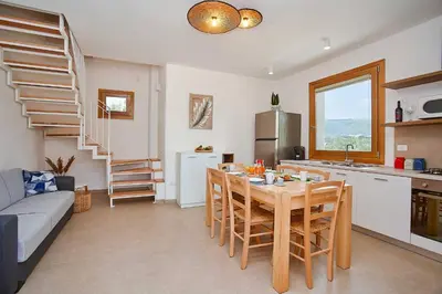a kitchen and a dining room with a table and chairs at Villa Ninfa in Castellammare del Golfo